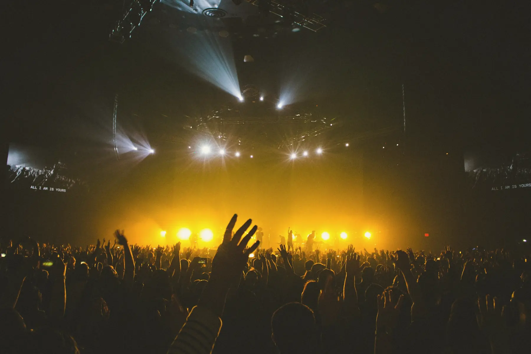 Concert crowd facing a lit stage